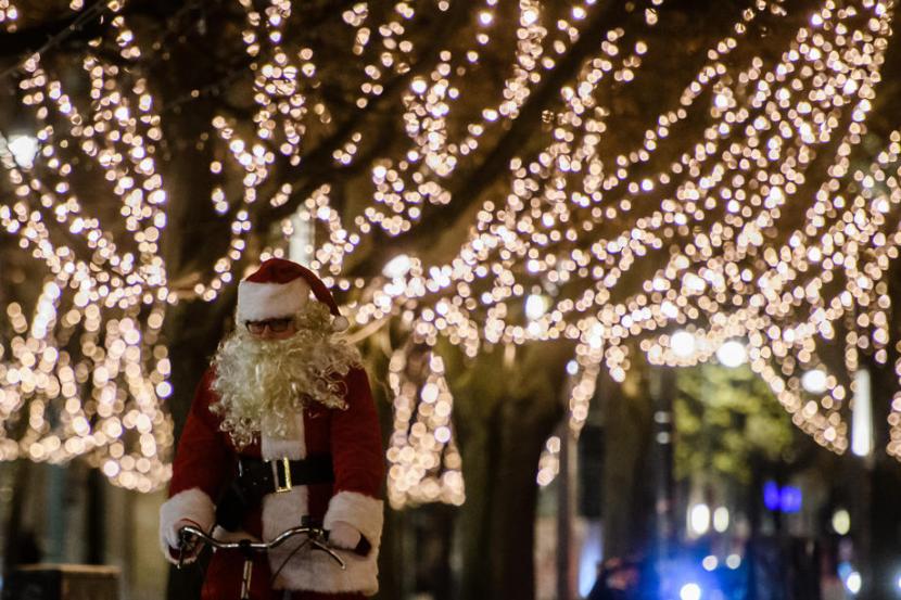 Seorang pria dengan kostum Sinterklas mengendarai sepeda di Berlin, Jerman, Senin (23/11). Sebelum merayakan Natal bersama keluarga warga Jerman diminta karantina mandiri.