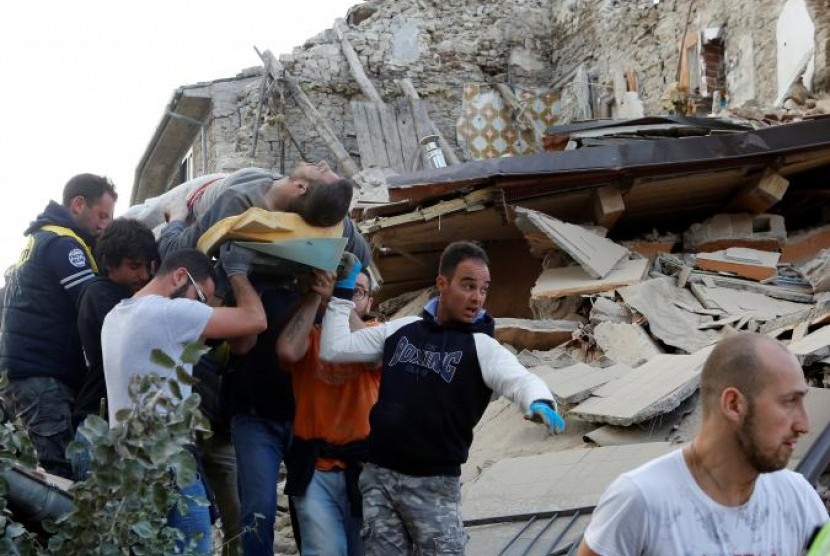Seorang pria dibawa setelah diselamatkan dari reruntuhan gempa bumi di Amatrice, Italia tengah, Rabu, 24 Agustus 2016.
