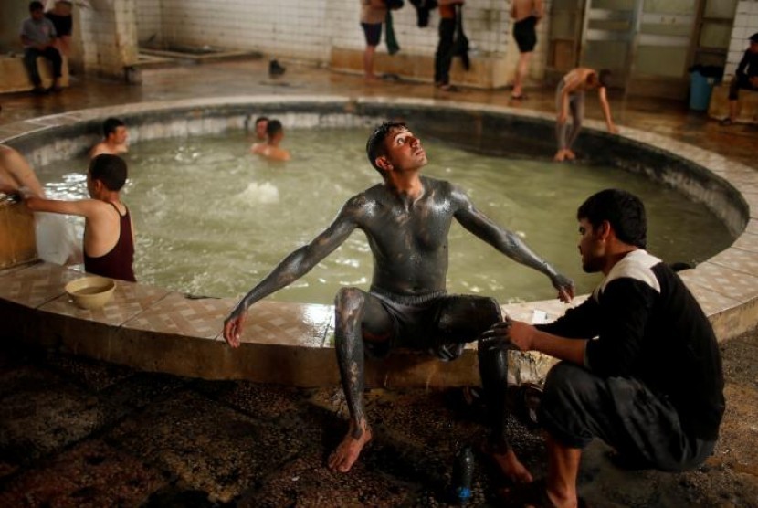 Seorang pria Irak menikmati mandi lumpur di kolam belerang di sebuah tempat spa di Hammam al-Alil, Mosul, Irak, 3 April 2017.