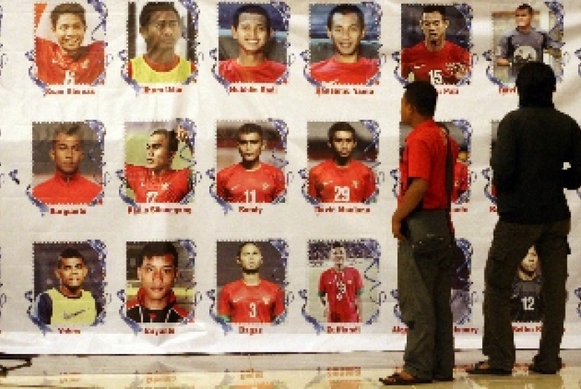 Seorang pria melihat foto pemain Timnas U 19.