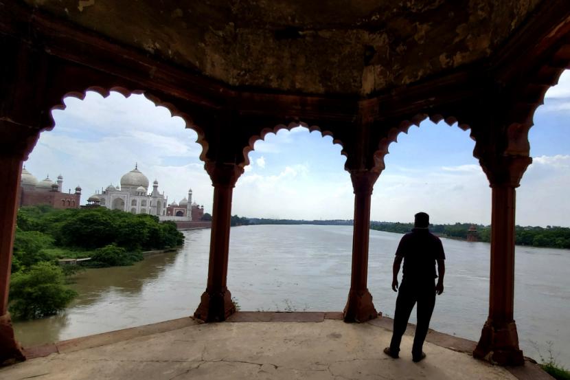 Seorang pria melihat sungai Yamuna yang meluap mengalir ke pinggiran monumen Taj Mahal di Agra, India, Rabu, 19 Juli 2023. India secara teratur menyaksikan banjir parah selama musim hujan, yang berlangsung antara Juni dan September dan membawa sebagian besar Curah hujan tahunan di Asia Selatan.