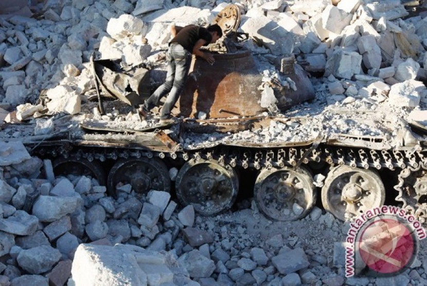 Seorang pria melihat tank Suriah yang hancur di Azaz, sekitar 47km dari Aleppo 