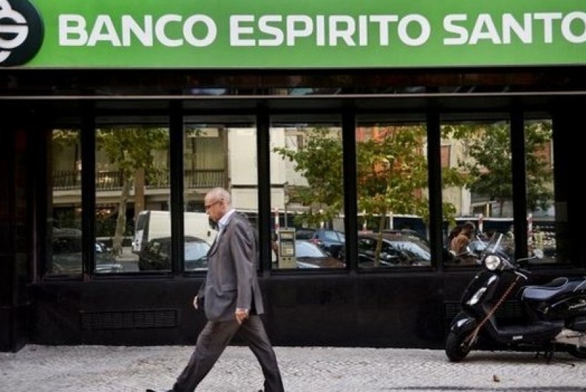 Seorang pria melintas di depan gedung bank swasta terbesar di Portugal Banco Espirito Santo.