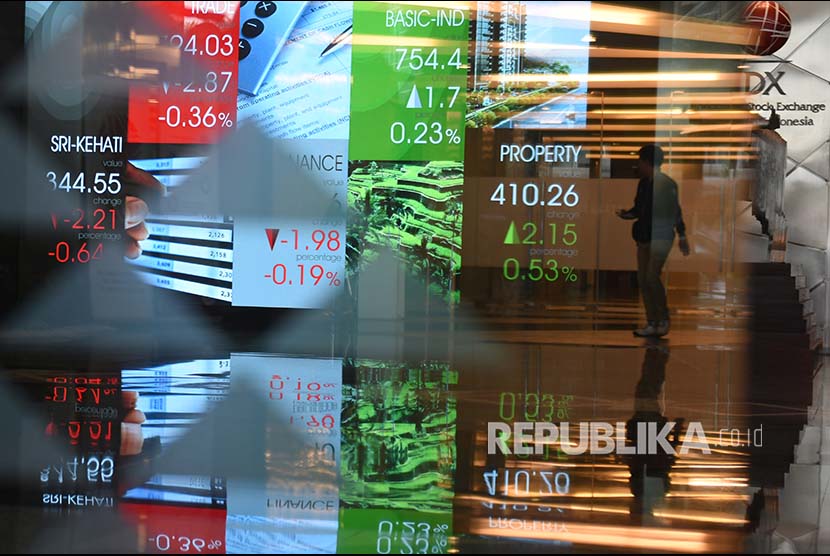 Seorang pria melintasi layar elektronik pergerakan saham di Bursa Efek Indonesia, Jakarta.ilustrasi