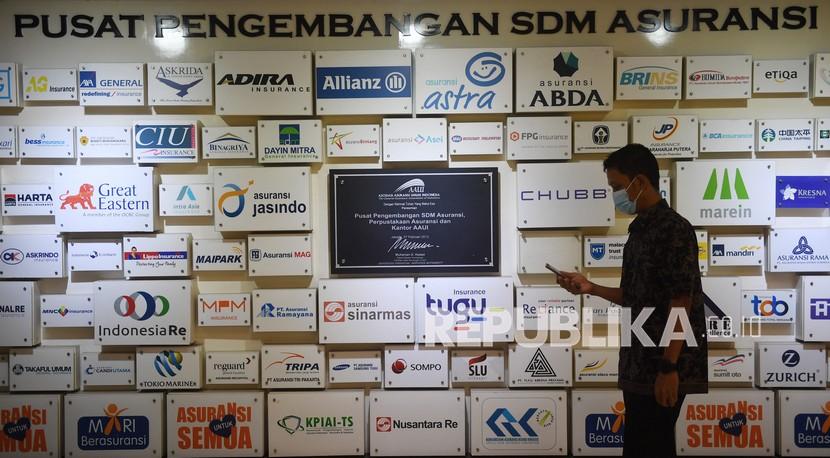 Seorang pria melintasi papan penyedia layanan asuransi di Jakarta, Senin (6/9). Asosiasi Asuransi Syariah Indonesia (AASI) membukukan kinerja asuransi syariah pada kuartal II 2021 mengalami pertumbuhan positif.