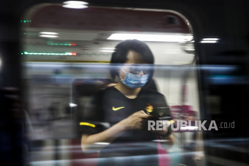 Seorang pria memakai masker di sebuah stasiun kereta api di  Singapura, Rabu (29/1/2020).  Seorang WNI di Singapura dilaporkan positif corona.