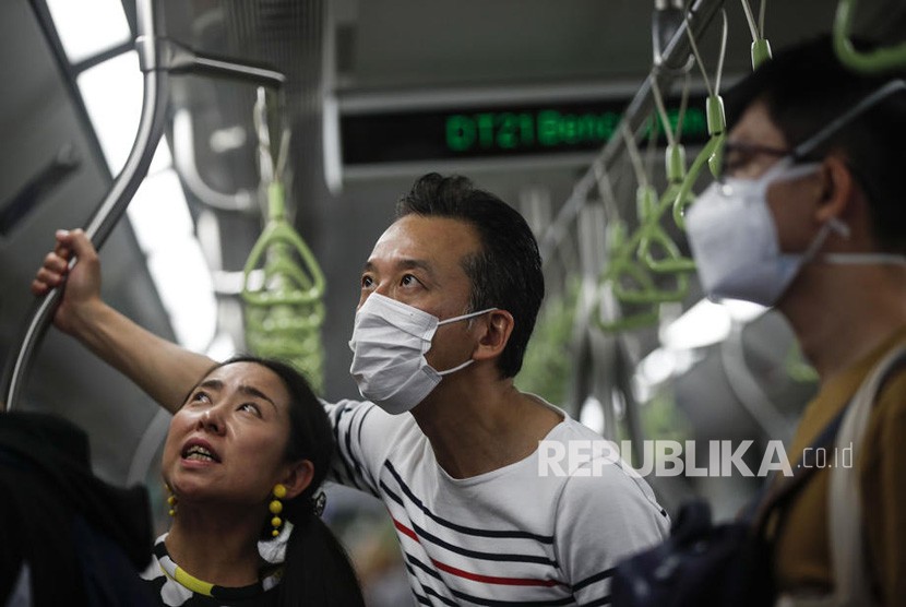 Seorang pria memakai masker di sebuah stasiun kereta api di  Singapura, Rabu (29/1/2020). Tujuh orang berasal dari Wuhan, Cina telah dinyatakan positif terkena virus corona di Singapura.