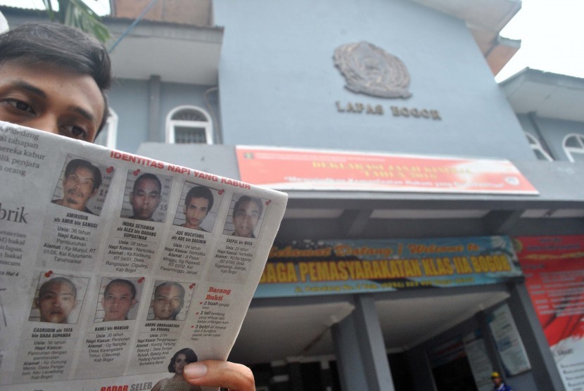 Seorang pria membaca suratkabar yang memuat foto narapidana yang melarikan diri, di Lembaga Pemasyarakatan (Lapas) Kelas II A Paledang, Kota Bogor, Jawa Barat, Senin (14/3).