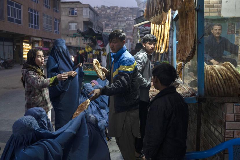 Seorang pria membagikan roti kepada warga Afghanistan di Kabul. Organisasi Buruh Internasional (ILO) mengungkapkan, lebih dari setengah juta warga Afghanistan telah kehilangan pekerjaan sejak Taliban berkuasa pada pertengahan Agustus tahun lalu. 