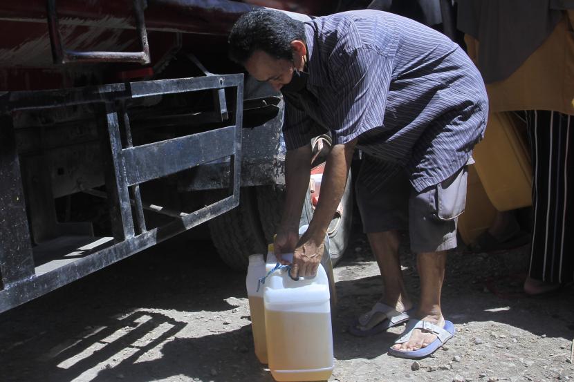 Seorang pria membawa dua jeriken minyak goreng curah (ilustrasi). Pemerintah Kota Ambon, Maluku, menerima minyak goreng curah subsidi sebanyak 68 ribu liter yang akan disalurkan ke 31 distributor.