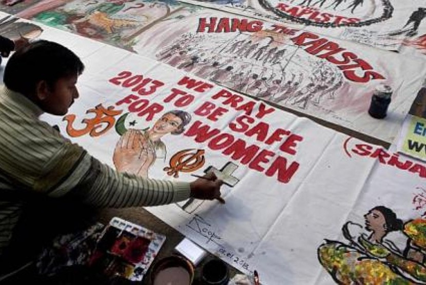 Seorang pria membuat spanduk untuk aksi protes menentang kekerasan terhadap wanita di India.
