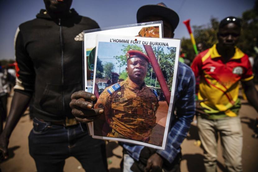 Seorang pria memegang potret Lt. Kolonel Paul Henri Sandaogo Damiba yang telah mengambil kendali Burkina Faso, di Ouagadougou, 25 Januari 2022. Serangan oleh ekstremis Islam meningkat lima bulan setelah tentara pemberontak menggulingkan presiden Burkina Faso yang terpilih secara demokratis pada Januari.
