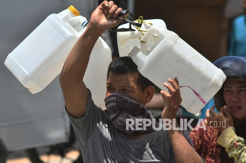 Seorang pria menawarkan jeriken bekas kepada warga di lokasi penjualan minyak goreng curah di Pasar Masomba di Palu, Sulawesi Tengah, Jumat (18/3/2022). Jeriken bekas tersebut dijual Rp7.000 per buah dan laris dibeli oleh warga yang datang untuk membeli minyak goreng curah.