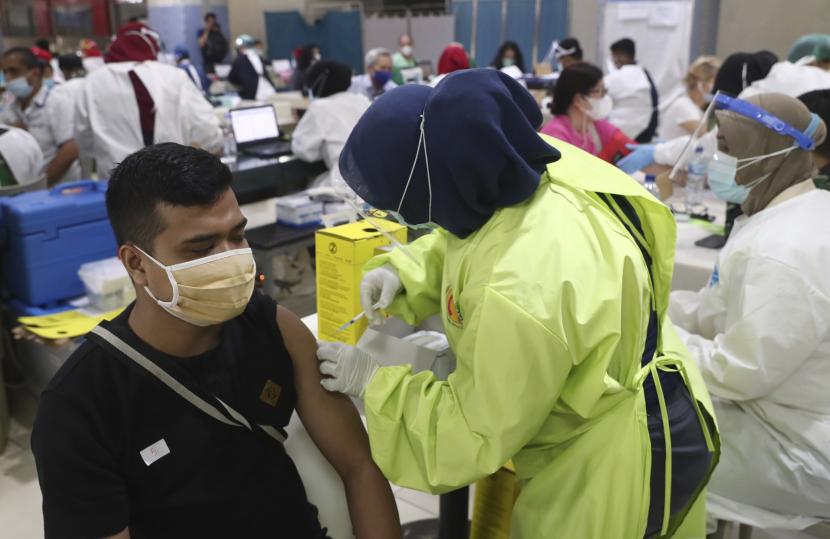  Seorang pria menerima suntikan vaksin COVID-19 saat vaksinasi massal untuk pedagang dan pekerja di Pasar Tanah Abang di Jakarta, Indonesia, Rabu, 17 Februari 2021. Vaksinasi cepat dan masif dinilai bisa membantu pemulihan ekonomi Indonesia.