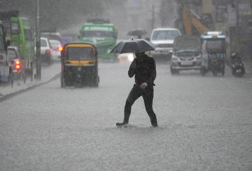 Seorang pria mengarungi jalan yang tergenang air saat hujan deras di Jammu, India, Kamis, 28 Juli 2022. Musim hujan di India berlangsung dari Juni hingga September.