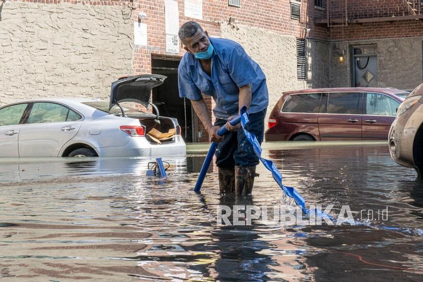  Seorang pria mengatur pompa air di tempat parkir setelah sisa-sisa Badai Ida menghasilkan hujan lebat dan menyebabkan banjir yang meluas di New York City, New York, AS, 02 September 2021.
