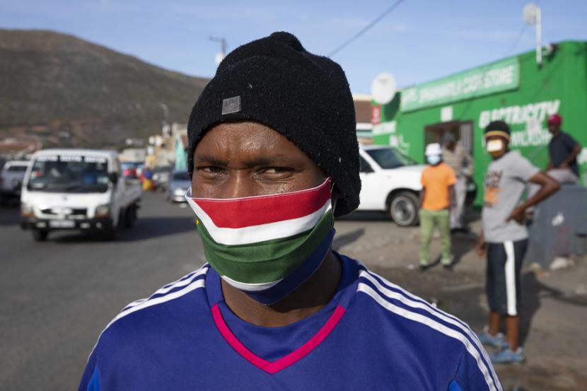 Seorang pria mengenakan masker dengan warna bendera Afrika Selatan. 