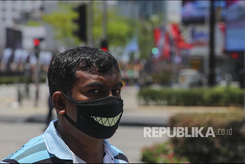 Seorang pria mengenakan masker pada hari pertama lock down Malaysia, Rabu (18/3).(Fazry Ismail/EPA EFE)