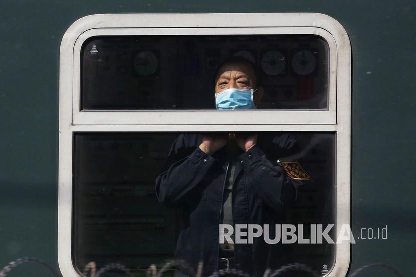 Seorang pria mengenakan masker untuk mencegah penyebaran virus corona saat keluar dari kereta di Beijing, Selasa (28/4). Kota Wuhan di China, yang merupakan pusat pandemi, kembali melaporkan kasus baru Covid-19 pada akhir pekan lalu.