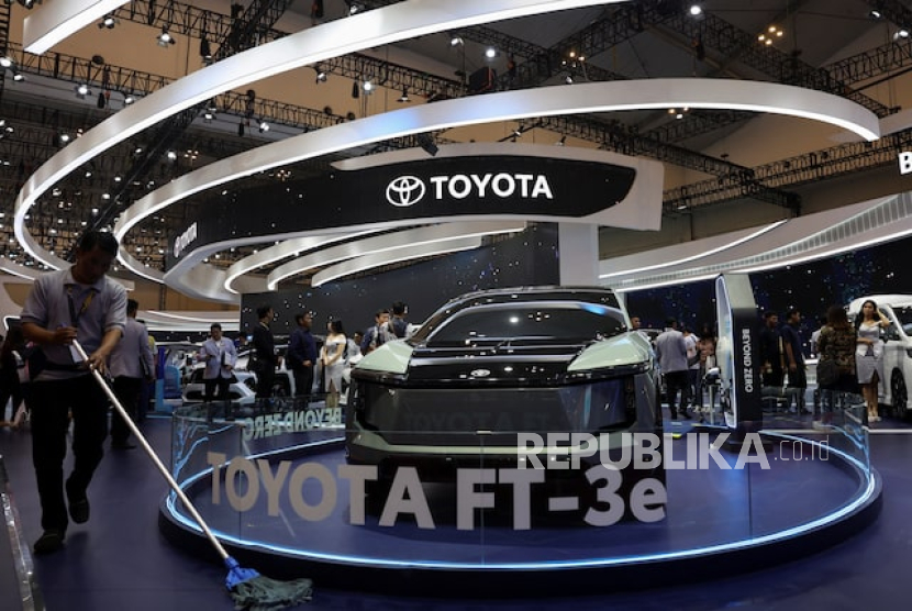 Seorang pria mengepel lantai di dekat Toyota FT-3e selama Pameran Mobil Internasional Indonesia di Tangerang, 18 Juli 2024.