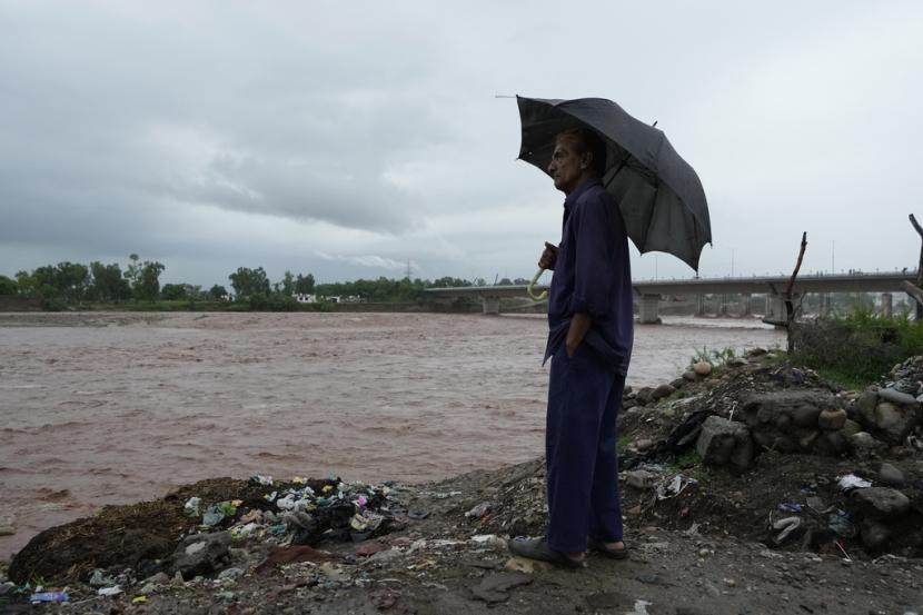 Seorang pria menyaksikan kenaikan permukaan air di sungai Tawi di Jammu, India, Rabu, 19 Juli 2023. Bagian dari kota suci kuno umat Hindu di India, Vrindavan dan Mathura, terendam banjir, Rabu (19/7/2023). 