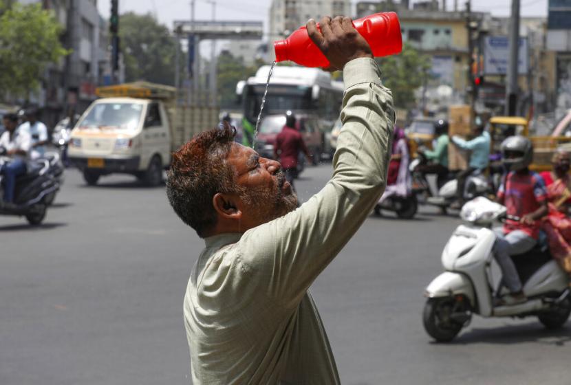 Seorang pria menyiramkan air ke wajahnya saat musim panas di Hyderabad, India, Sabtu, 14 Mei 2022. Ilmuwan Prediksi India dan Pakistan Dihajar Gelombang yang Lebih Panas