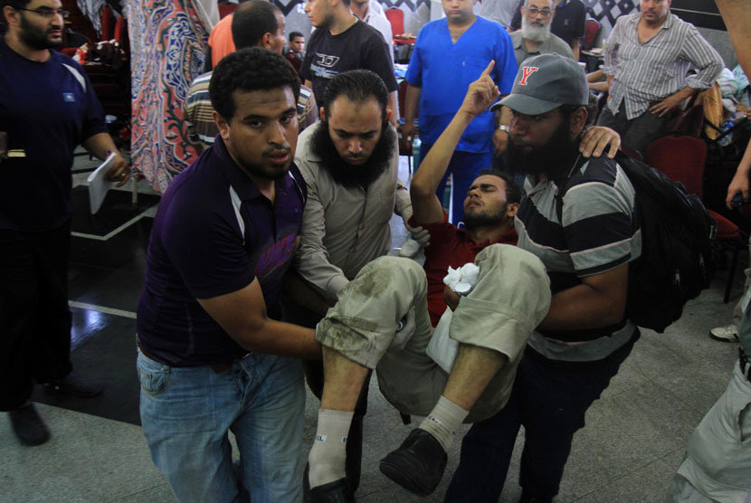  Seorang pria pendukung Presiden Mursi terluka dan dibawa ke rumah sakit darurat setelah ditembaki tentara di Kairo, Mesir, Senin (8/7). (AP/Ahmed Gomaa)
