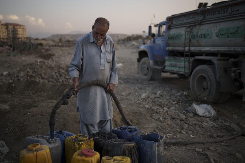 Seorang pria penjual air mengisi wadah untuk pengungsi internal dari bagian timur negara itu di lingkungan miskin di Kabul, Afghanistan, Senin, 27 September 2021.