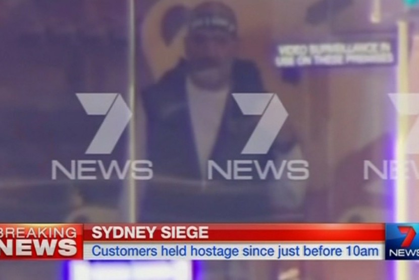 Seorang pria tampak berdiri di sebuah kafe tempat sekitar 40 orang disandera di Sydney, Australia