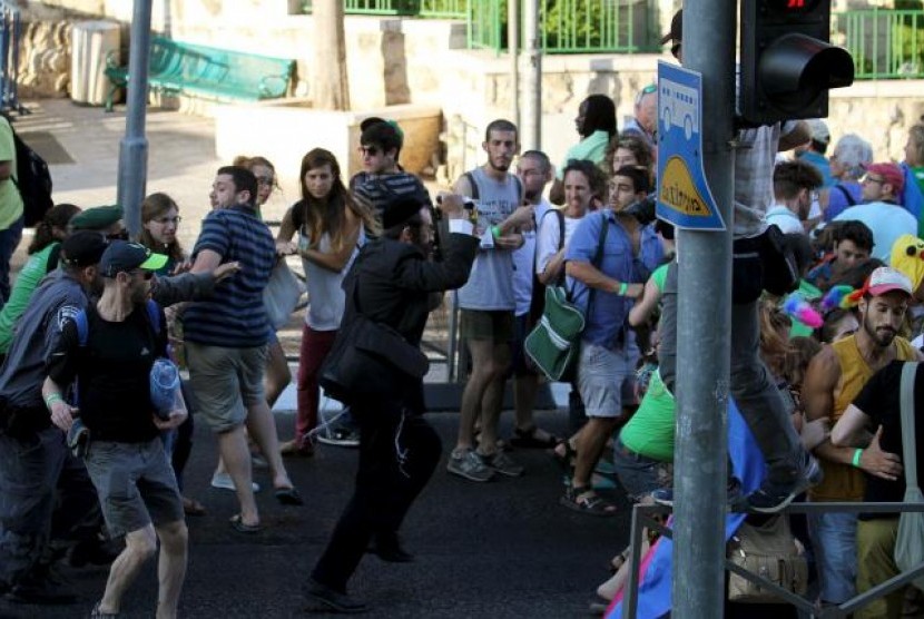 Seorang pria Yahudi ortodoks (tengah) menusuk enam peserta parade gay di Yerusalem, Kamis (30/7).