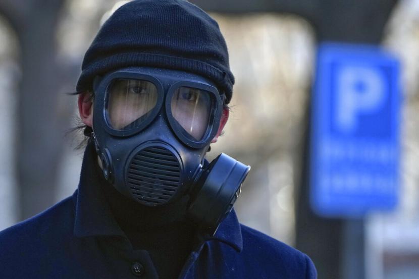 Seorang pria yang memakai masker gas berjalan di sebuah jalan di Beijing, Selasa, 13 Desember 2022. Beberapa universitas di China mengatakan akan mengizinkan mahasiswanya menyelesaikan semester dari rumah dengan harapan dapat mengurangi potensi wabah COVID-19 yang lebih besar selama periode tersebut. 