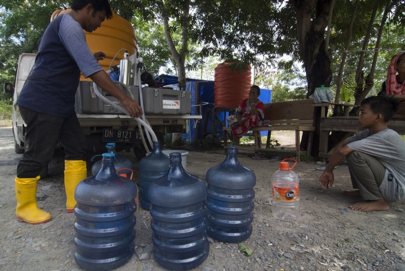 Seorang warga mengisi air minum ke dalam galon isi ulang (ilustrasi).