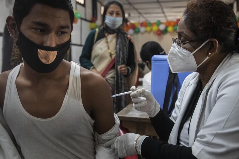 Seorang remaja India menerima vaksinasi untuk COVID-19 di sebuah sekolah negeri di Gauhati, India, Senin, 3 Januari 2022.