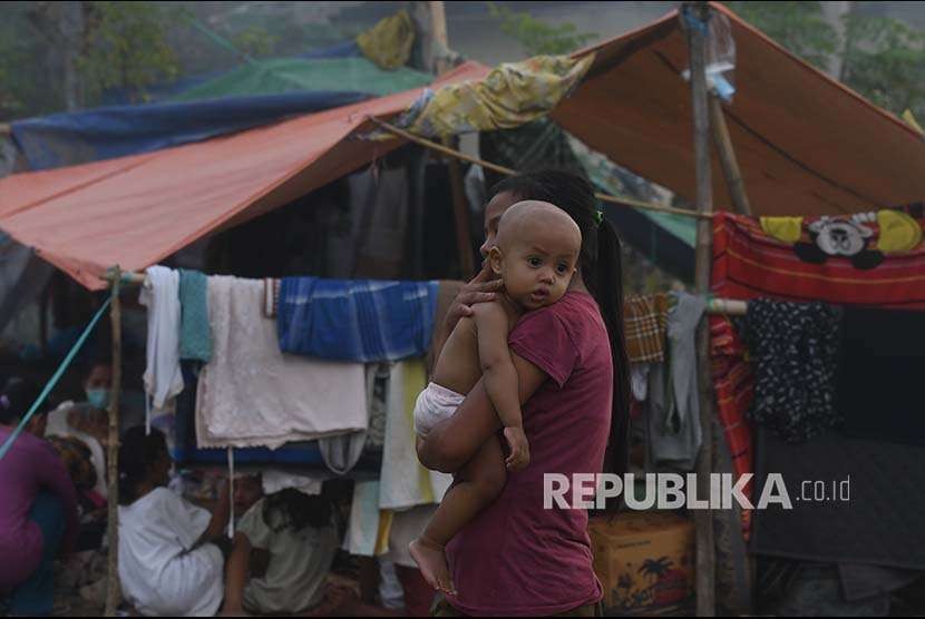 Seorang remaja mengendong balita di tempat penampungan pengungsi korban gempa bumi di Pemenang, Lombok Utara, Lombok Utara, NTB, Selasa (7/8). 