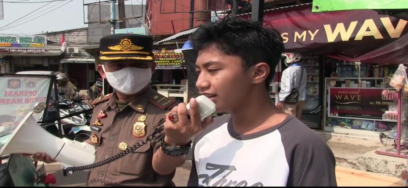 Seorang remaja SMP, Cahyo (13 tahun) melafalkan Pancasila dan menyanyikan Indonesia Raya akibat terjaring razia masker di Jalan Raya Srengseng, Kembangan, Jakarta Barat, Selasa (1/9).