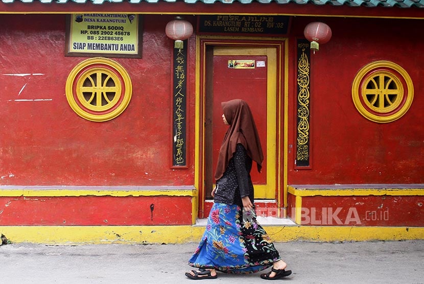 Seorang santri melintas di depan poskamling sebuah Pondok Pesantren di Kampung Wisata Pecinan, Lasem, Jawa Tengah. Bangunan kuno serta riwayat sejarah yang membentuk akulturasi budaya Jawa dan Tionghoa di kawasan tersebut.