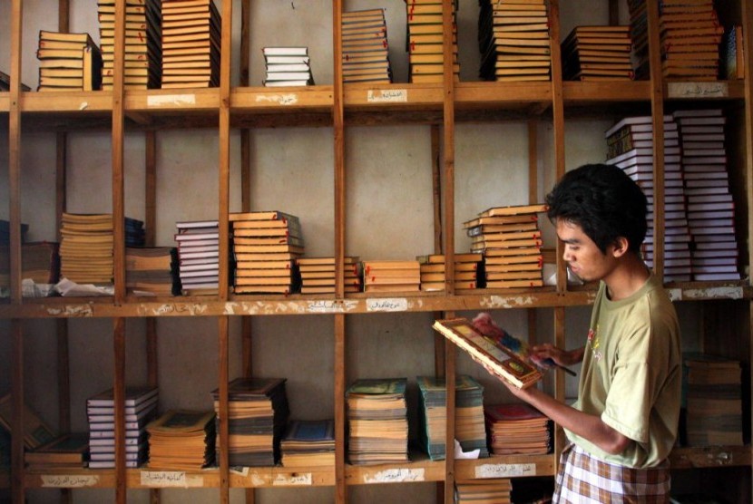 Seorang santri membersihkan koleksi Kitab Kuning di Pondok Pesantren Petuk, Kediri, Jawa Timur.