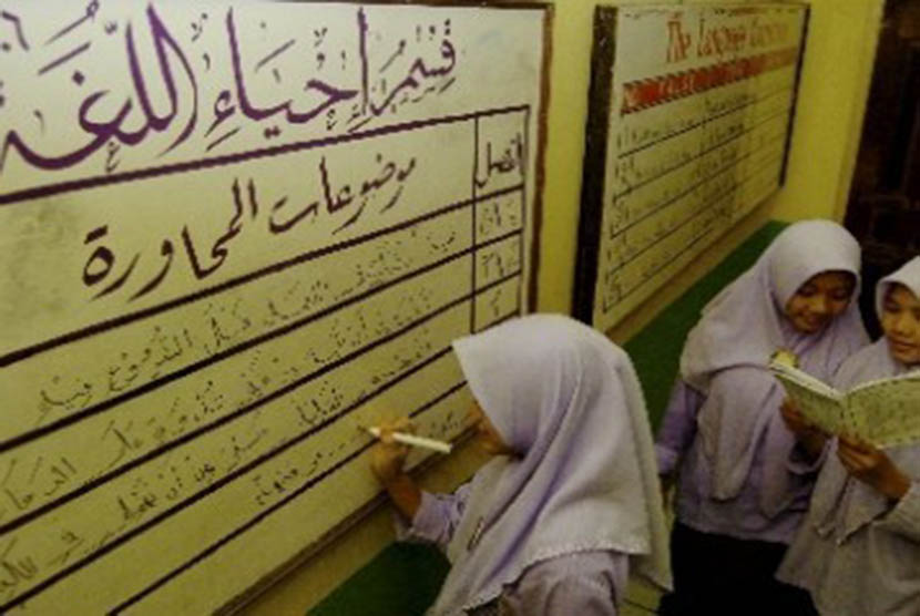 Seorang santri menulis aksara Arab di sebuah papan bahasa/Ilustrasi