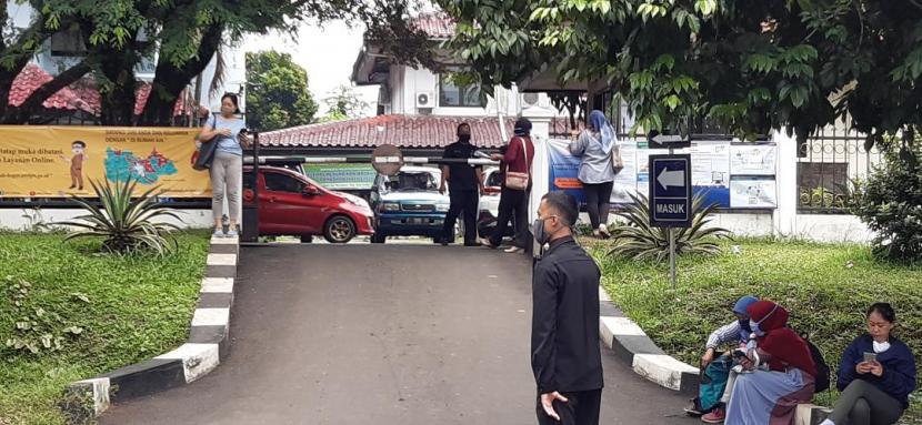 Seorang satpam menjaga gerbang BPN Kab Bogor yang diportal