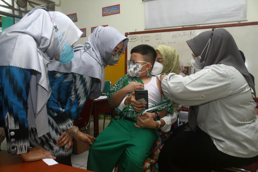 Seorang siswa didampingi orangtua dan kedua gurunya mendapatkan vaksin Covid-19 saat giat vaksinasi yang digelar Polda Kalimantan Barat di Sekolah Dasar Al Azhar, Pontianak, Kalimantan Barat, Rabu (16/3/2022). (Ilustrasi)