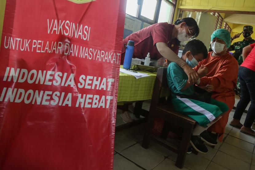 Seorang siswa disuntik vaksin COVID-19 saat vaksinasi bagi anak usia 6-11 tahun di SD Negeri 11 Langkai, Palangkaraya, Kalimantan Tengah, Kamis (30/12/2021). Berdasarkan data Satgas COVID-19 per 29 Desember 2021 pukul 12.00 WIB, sebanyak 158,9 juta masyarakat atau 76,32 persen telah mengikuti vaksin tahap pertama dan 112,2 juta orang atau 53,91 persen sudah mendapat vaksin dosis kedua dari target 208 juta orang untuk sasaran vaksin nasional.