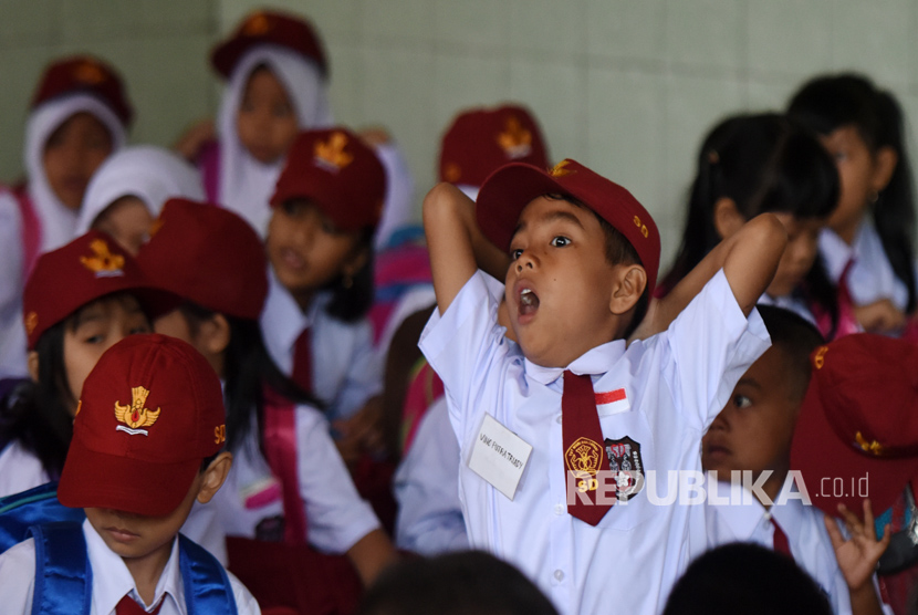 Seorang siswa kelas 1 menguap saat mengikuti kegiatan pengenalan siswa pada hari pertama sekolah di SD Negeri. 