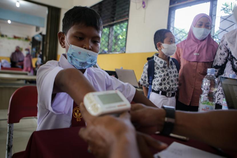 Seorang siswa melakukan skrining kesehatan sebelum disuntik vaksin COVID-19 di SDN Kunciran 7, Kota Tangerang, Banten, Kamis (28/7/2022). Pemerintah Kota Tangerang melakukan vaksinasi COVID-19 jemput bola untuk para siswa sekolah dasar guna menciptakan kekebalan komunal di tengah pembelajaran tatap muka (PTM) 100 persen.