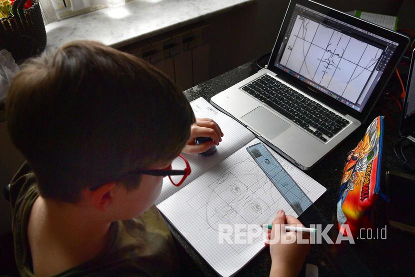 Seorang siswa mengerjakan pekerjaan rumah dengan laptop di rumahnya, Genova, Italia. Menteri Pendidikan Italia Lucia Azzolina mengatakan semua sekolah dibuka September. Ilustrasi.