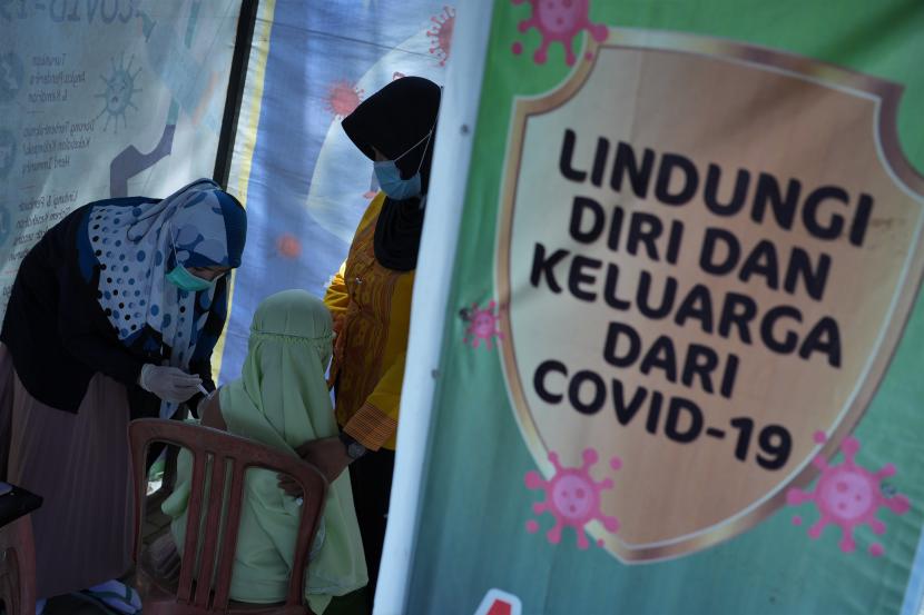 Seorang siswa sekolah dasar menerima suntikan vaksin COVID-19 di RS Abu Nawas Kota Kendari, Kendari, Sulawesi Tenggara, Jumat (29/7/2022). Dinas Kesehatan Kota Kendari mencatat penerima vaksinasi COVID-19 dosis ketiga (booster) mencapai 43.361 jiwa dari sasaran sebanyak 265.147 orang. 
