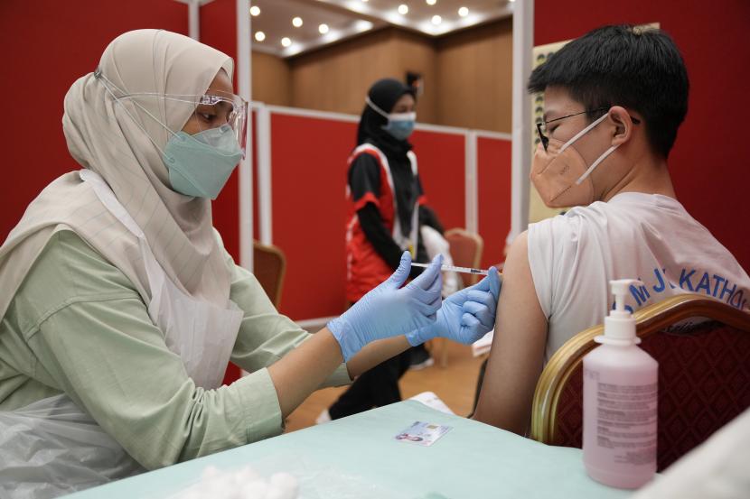 Seorang siswa sekolah menengah, menerima dosis vaksin Pfizer terhadap penyakit virus corona (COVID-19) di pusat vaksin di Shah Alam, Malaysia, Senin, 20 September 2021. Malaysia dan Singapura akan menindak mereka yang menolak divaksin Covid-19.