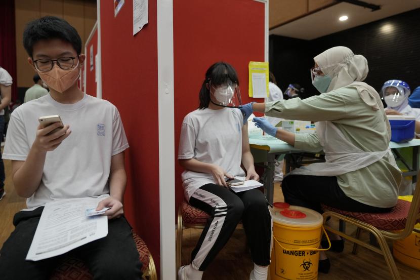 Seorang siswa sekolah menengah, tengah, menerima dosis vaksin Pfizer terhadap penyakit virus corona (COVID-19) di pusat vaksin di Shah Alam, Malaysia, Senin, 20 September 2021.