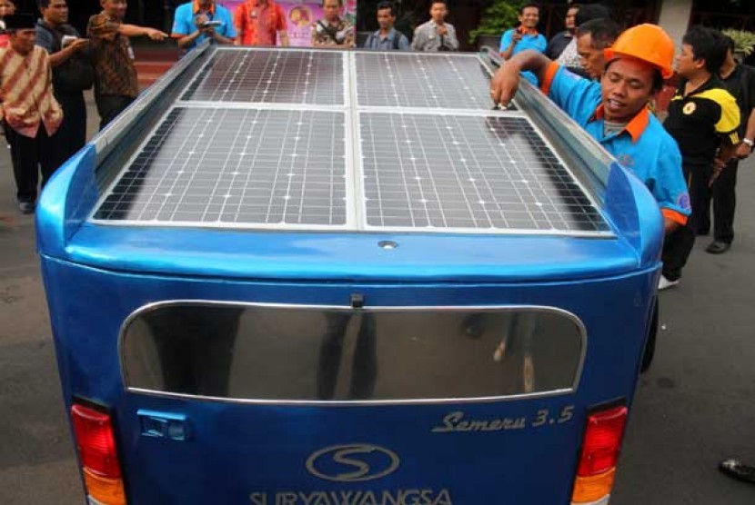   Seorang siswa SMK Muhammadiyah membersihkan panel tenaga surya di mobil hibrid tenaga surya yang dikendarainya di Pendopo kabupaten Malang, Jawa Timur, Jumat (2/11).