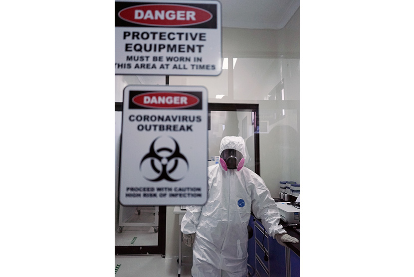 Seorang staf mengenakan Alat Pelindung Diri (APD) lengkap berada di laboratorium yang akan digunakan untuk tempat pemeriksaan COVID-19. Ilustrasi