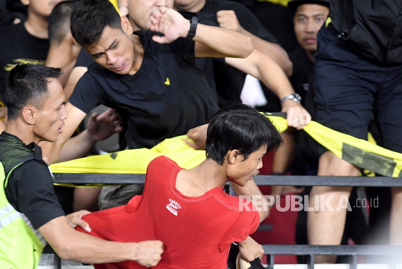 Seorang suporter Indonesia (kanan) berusaha menyerang suporter Malaysia saat pertandingan timnas Indonesia melawan timnas Malaysia pada Kualifikasi Piala Dunia 2022 Grup G Zona Asia di Stadion Gelora Bung Karno (GBK), Senayan, Jakarta, Kamis (5/9/2019).